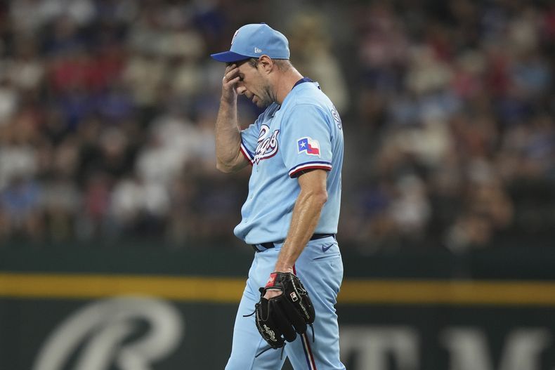 Max Scherzer, abridor de los Rangers de Texas, reacciona después de golpear a Willy Adames, de los Ceveceros de Milwaukee, con un lanzamiento con la casa llena, con lo que anotó Tyrone Taylor durante la tercera entrada del juego de béisbol en Arlington, Texas, el domingo 20 de agosto de 2023. (AP Foto/LM Otero)
