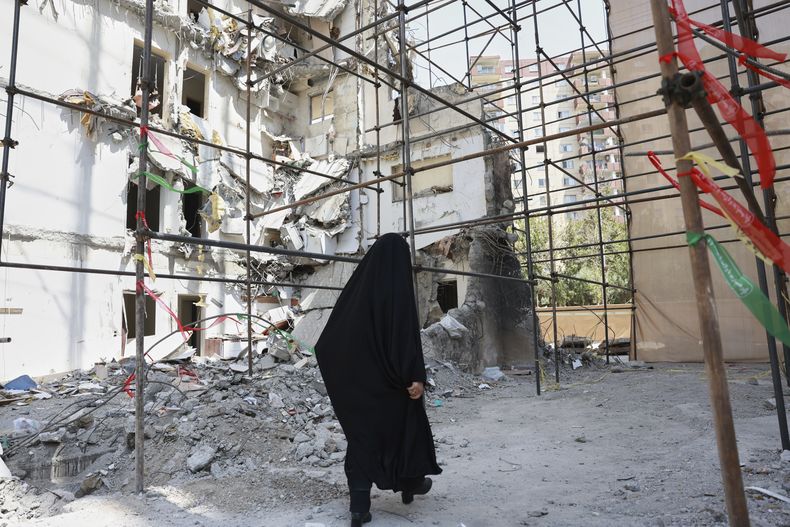 ARCHIVO - Una mujer pasa junto a un edificio dañado por un letal ataque israelí el 13 de junio, en un complejo residencial en Teherán, Irán, el 19 de julio de 2025. (AP Foto, archivo)