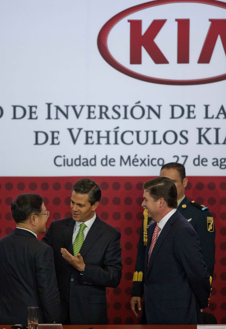 El presidente mexicano Enrique Pe&ntilde;a Nieto, centro, conversa con el vicepresidente y director general de KIA, Hyoung-Keun Lee, izquierda, y el gobernador del estado de Nuevo Le&oacute;n, Rodrigo Medina, derecha, durante el anuncio de una inversi&oac