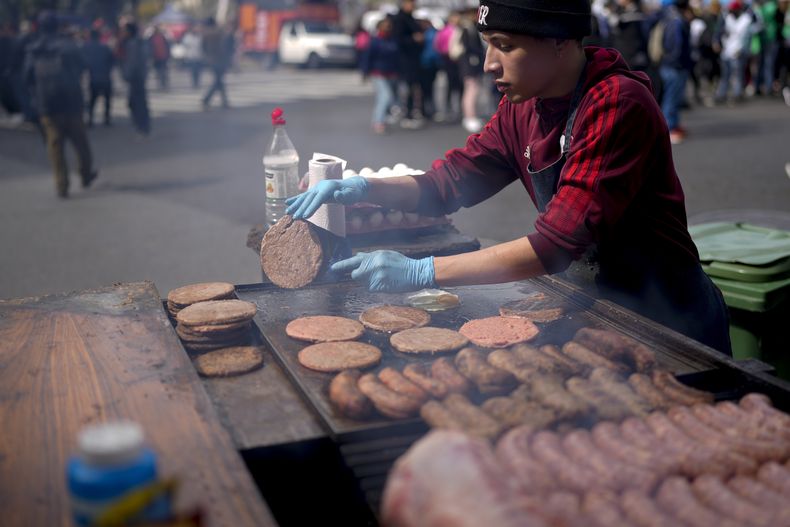 Un vendedor ambulante cocina carne en una calle de Buenos Aires, Argentina, el miércoles 11 de septiembre de 2024. (AP Foto/Natacha Pisarenko)