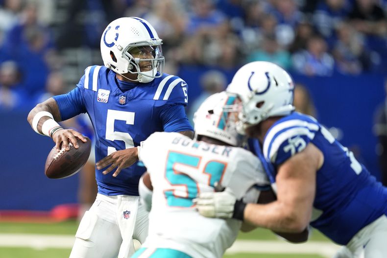 El quarterback de los Colts de Indianápolis, Anthony Richardson (5), es presionado por el apoyador de los Miami Dolphins, Tyus Bowser (51), durante la segunda mitad de un partido de fútbol americano de la NFL, el domingo 20 de octubre de 2024 en Indianapolis. (AP Foto/Michael Conroy)