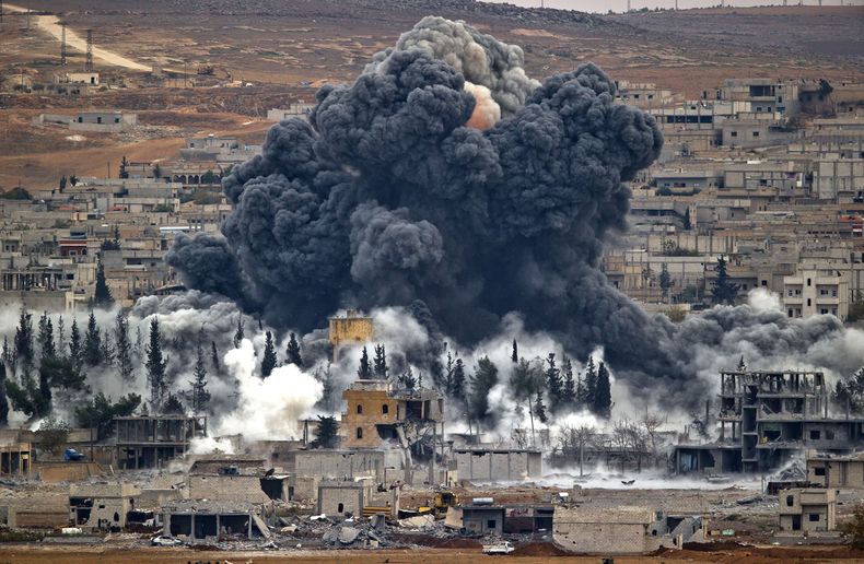 ARCHIVO - En esta foto de archivo del 17 de noviembre de 2014 se ve una nube que se alza de la ciudad siria de Kobani tras un ataque a&eacute;reo de EEUU, visto desde Suruc, en el lado turco de la frontera. Los ataques a&eacute;reos han causado 900 muerto