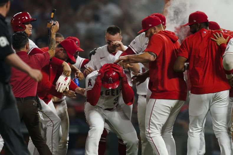 Los Angelinos de Los Ángeles felicitan a Taylor Ward, tras vencer a los Astros de Houston en 10 innings, el sábado 15 de julio de 2023 (AP Foto/Ryan Sun)