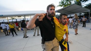 Un agente de seguridad asiste a un aficionado que esperaba entrar al estadio para la final de la Copa América entre Argentina y Colombia el domingo 14 de julio del 2024.(AP Foto/Lynne Sladky)