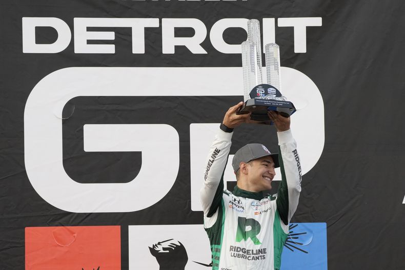 Alex Palou levanta el trofeo de ganador tras conquistar el Gran Premio de Detroit de la Indycar el domingo 4 de junio del 2023. (AP Foto/Carlos Osorio)