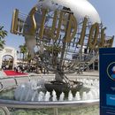 Entrada de los Universal Studios Hollywood con un letrero de los protocolos COVID-19 implementados en Los Ángeles, el 16 de abril de 2021. (Foto AP/Damián Dovarganes, Archivo)