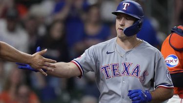 Wyatt Langford, de los Rangers de Texas, es felicitado luego de batear un jonrón de dos carreras ante los Astros de Houston, el viernes 11 de julio de 2025 (AP Foto/Kevin M. Cox)