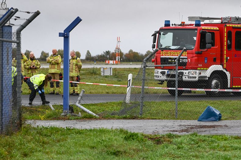 Investigadores inspeccionan el lugar donde se encuentra una sección dañada de una valla, en la entrada del recinto aeroportuario del aeropuerto de Leipzig/Halle, en Schkeuditz, Alemania, el domingo 18 de octubre de 2026. (Heiko Rebsch/dpa vía AP)