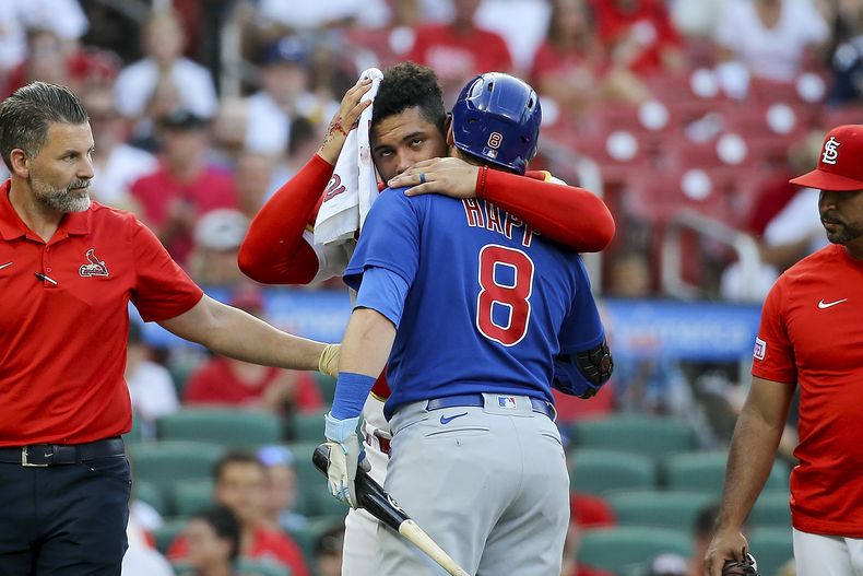 El venezolano Willson Contreras, de los Cardenales de San Luis, abraza a Ian Happ, de los Cachorros de Chicago, quien lo golpeó con el movimiento de su bate en el juego del jueves 27 de julio de 2023 (AP Foto/Scott Kane)