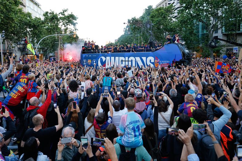 Rodeados de fanáticos, los jugadores del Barcelona celebran en un autobus descapotable después de la obtención del campeonato de La Liga española, el lunes 11 de mayo de 2026, en Barcelona, España. (AP Foto/Joan Monfort)