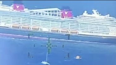 Esta imagen proporcionada por la Guardia Costera de Estados Unidos muestra un crucero rescatando a gente desde un catamarán en problemas que estaba haciendo aguas a cientos de millas de la costa de Bermudas, el 10 de noviembre de 2024. (Guardia Costera de Estados Unidos via AP)