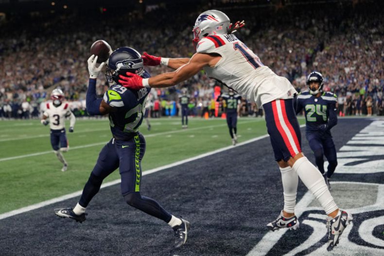 Josh Jobe (29), de los Seahawks de Seattle, intercepta un pase en la zona de anotación que buscaba las manos de Mack Hollins (13), de los Patriots de Nueva Inglaterra durante la segunda mitad del partido inaugural de la NFL, el miércoles 9 de septiembre de 2026, en Seattle. (AP Foto/Stephen Brashear)