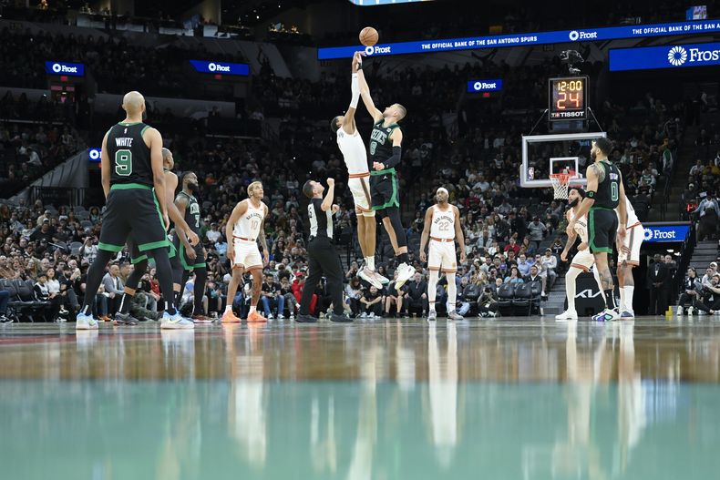 Kristaps Porzingis de los Celtics de Boston salta junto a Victor Wembanyama de los Spurs de San Antonio en el encuentro en el TD Garden el domingo 31 de diciembre del 2023. (AP Foto/Darren Abate)