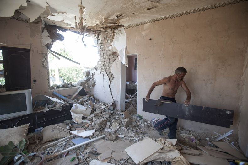 Un hombre retira escombros de su apartamento en un edificio da&ntilde;ado por obuses en Slaviansk, Ucrania, jueves 10 de julio de 2014. Las fuerzas del gobierno han reducido a la mitad el territorio en poder de los rebeldes, que a su vez empiezan a mostra