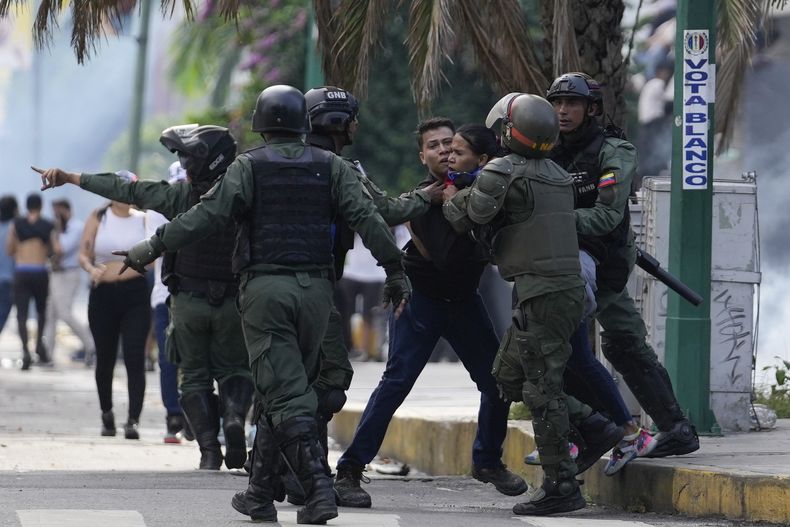 ARCHIVO - La policía detiene a manifestantes que protestan contra el anuncio oficial de resultados electorales que dio la victoria al presidente Nicolás Maduro, un día después de las votaciones en Caracas, Venezuela, el 29 de julio de 2024. (AP Foto/Matías Delacroix, Archivo)