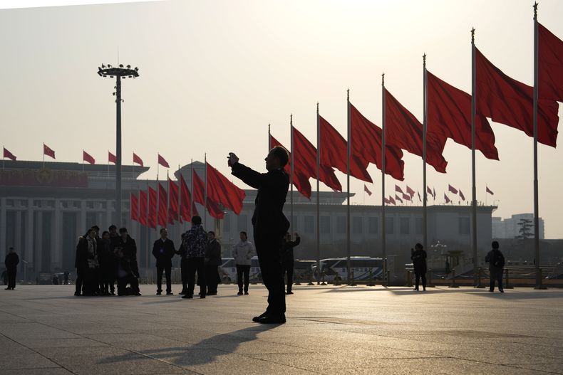 Un hombre toma fotos cerca de banderas rojas en la plaza de Tiananmen antes de la sesión de clausura de la Conferencia Consultiva Política Popular China (CPPCC) en Beijing, el domingo 10 de marzo de 2024. La conferencia es un organismo consultivo del Congreso Nacional Popular, que termina el lunes. (AP Foto/Ng Han Guan)
