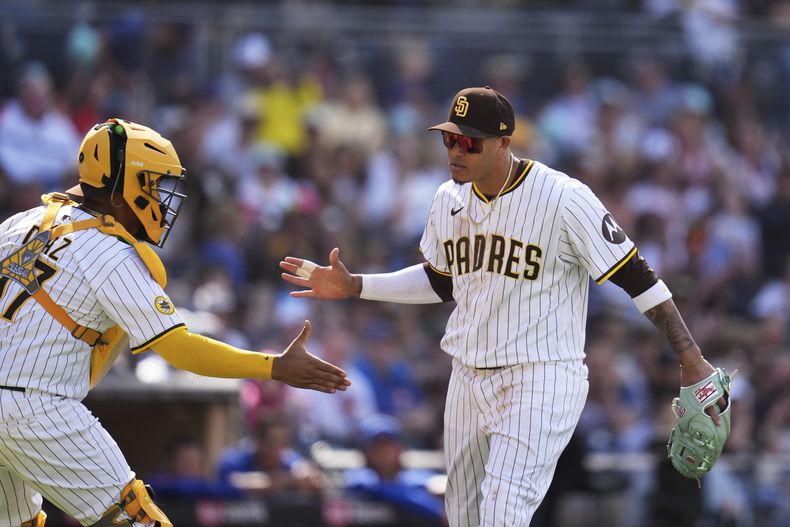 El dominicano Manny Machado, de los Padres de San Diego, festeja con su compañero, el receptor venezolano Elías Díaz, en el encuentro ante los Cachorros de Chicago, el miércoles 16 de abril de 2025 (AP Foto/Gregory Bull)