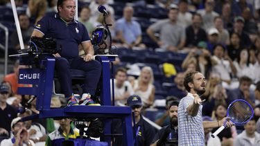 Daniil Medvedev, abajo a la derecha, de Rusia, reacciona cerca del juez de silla, Greg Allensworth, izquierda, después de que un fotógrafo corriera dentro de la cancha durante un punto en el partido contra Benjamin Bonzi, de Francia, en la primera ronda del torneo de tenis US Open, el domingo 24 de agosto de 2025, en Nueva York. (AP Foto/Adam Hunger)