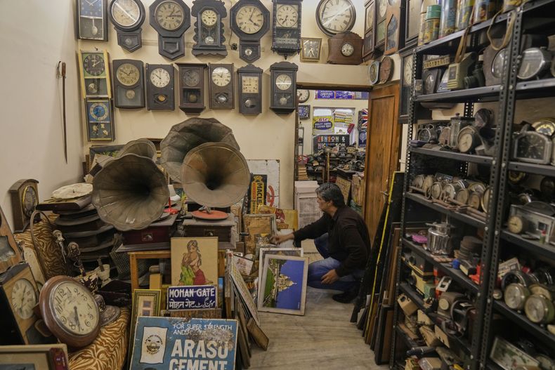 Aditya Vij, un antropólogo indio y ávido coleccionista de artefactos antiguos, saca viejos carteles en su casa en Nueva Delhi, India, el viernes 18 de abril de 2025. (AP Foto/Manish Swarup)