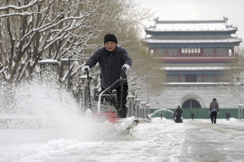 En esta imagen, distribuida por la agencia noticiosa Xinhua, un trabajador utiliza una máquina para retirar la nieve del pavimento en el parque Yongdingmen, en Beijing, el 11 de diciembre de 2023. (Li He/Xinhua vía AP)