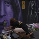 Una fan coloca una flor para conmemorar la muerte de Ozzy Osbourne en Birmingham, Inglaterra, el miércoles 23 de julio de 2025. (Foto AP/Kin Cheung)