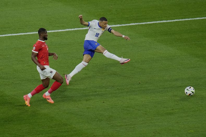 El austriaco Kevin Danso (izquierda) observa el remate del francés Kylian Mbappé en el partido por el Grupo D de la Eurocopa, el lunes 17 de junio de 2024, en Duesseldorf. (AP Foto/Hassan Ammar)