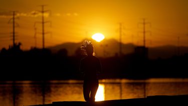 ARCHIVOS - Una muer corre cerca del Lago Tempe Town al amanecer, el 12 de julio de 2023 en Tempe, Arizona. (AP Foto/Matt York, archivo)