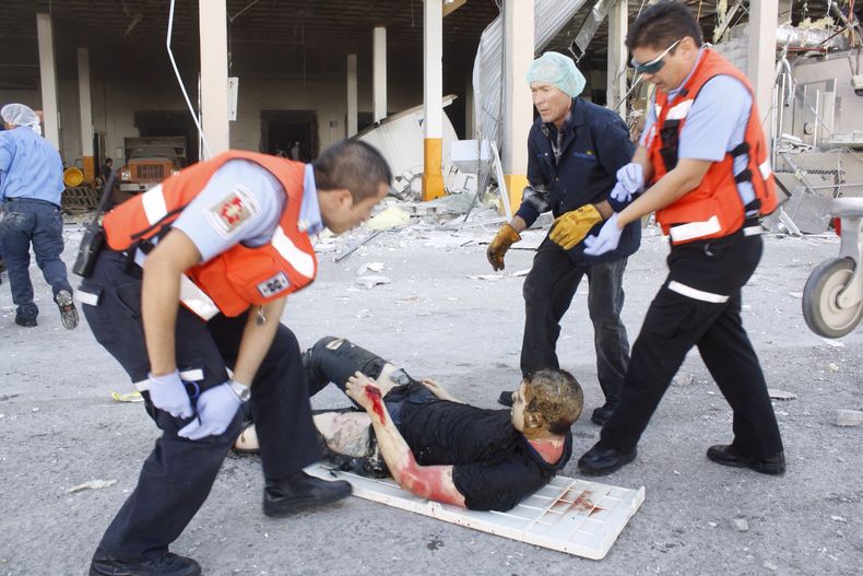 Socorristas ayudan a un hombre que result&oacute; herido por una explosi&oacute;n en una f&aacute;brica de dulces en Ciudad Ju&aacute;rez, M&eacute;xico, el jueves 24 de octubre de 2013. La explosi&oacute;n en la f&aacute;brica Dulces Blueberry hizo que e