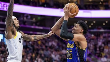 El alero de los Lakers de Los Ángeles, Christian Wood (35), va al aro contra el escolta del Jazz de Utah, Jordan Clarkson, a la izquierda, durante la primera mitad del partido de baloncesto de la NBA, el sábado 13 de enero de 2024, en Salt Lake City. (AP Foto/Spenser Heaps)
