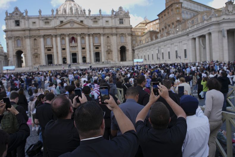 La multitud toma fotos cuando sale humo negro de la chimenea de la Capilla Sixtina en el Vaticano el 8 de mayo del 2025 (AP foto/Emilio Morenatti)