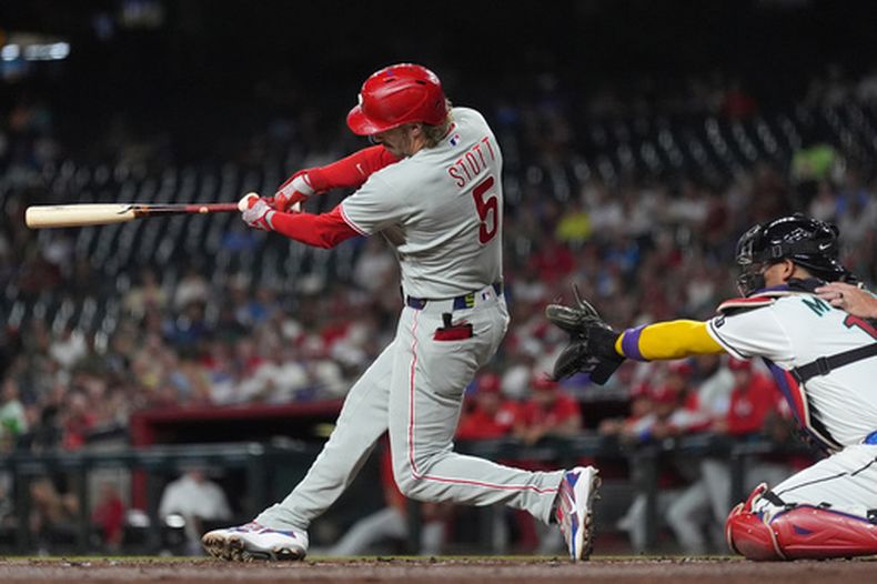 Bryson Stott (5), de los Filis de Filadelfia, conecta un jonrón mientras el receptor de los Diamondbacks de Arizona observa durante la segunda entrada del juego de béisbol de Grandes Ligas, el lunes 31 de agosto de 2026, en Phoenix. (AP Foto/Ross D. Franklin)
