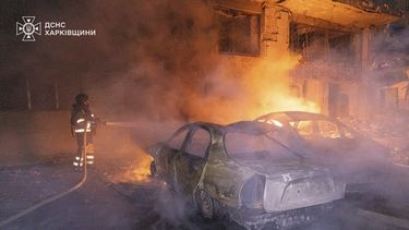 En esta imagen proporcionada por los Servicios Ucranianos de Emergencia el jueves 12 de junio de 2025, un rescatista apaga un incendio en un auto cerca de un edificio dañado por un ataque ruso en Járkiv, Ucrania. (Servicios Ucranianos de Emergencia via AP)