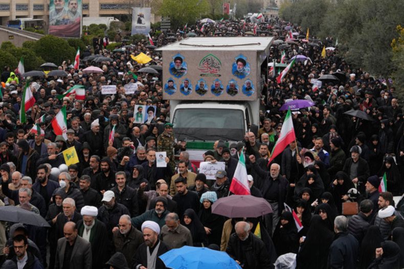Ciudadanos iraníes siguen un camión que transporta los ataúdes del ministro de Inteligencia de Irán, Esmail Khatib, y, según funcionarios iraníes, también los de su esposa e hija, durante una procesión fúnebre, el viernes 20 de marzo de 2026, en Teherán, Irán. (AP Foto/Vahid Salemi)