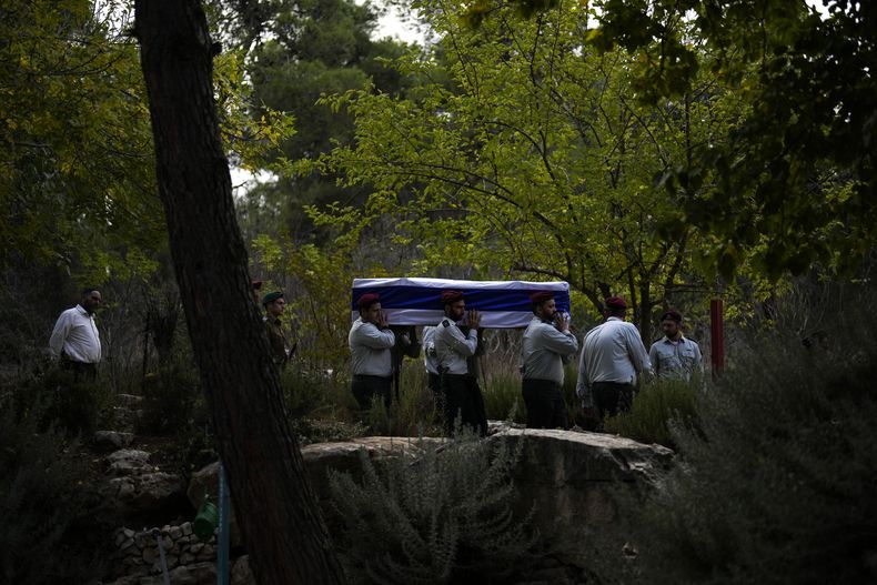 Soldados israelíes cargan un féretro cubierto con la bandera de Israel en el que yace el mayor Tal Cohen durante su funeral en el cementerio Givat Shaul, el martes 10 de octubre de 2023, en Jerusalén. La más reciente guerra entre Israel y los palestinos resonó en todo el mundo el martes, mientras gobiernos extranjeros intentaban determinar cuántos de sus ciudadanos habían muerto, estaban desaparecidos o necesitaban de asistencia médica o de vuelos para volver a casa. (AP Foto/Francisco Seco)