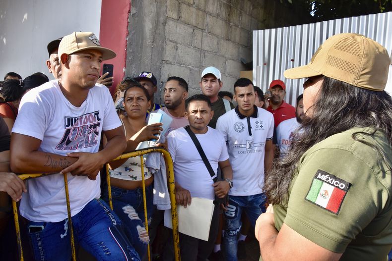 Una funcionaria de Migración mexicana explica a migrantes que el permiso para viajar a través de México hacia la frontera con Estados Unidos había quedado suspendido después de que la Oficina de Aduanas y Protección Fronteriza de Estados Unidos anunciara que la aplicación CBPOne dejará de utilizarse para admitir a migrantes, en Tapachula, México, el martes 21 de enero de 2025. (AP Foto/Édgar H. Clemente)