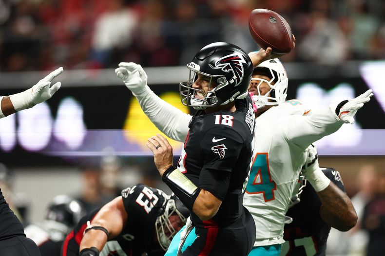Kirk Cousins (18), quarterback de los Falcons de Atlanta, lanza durante la segunda mitad de un juego de fútbol americano de la NFL contra los Dolphins de Miami, el domingo 26 de octubre de 2025, en Atlanta. (AP Photo/Colin Hubbard)