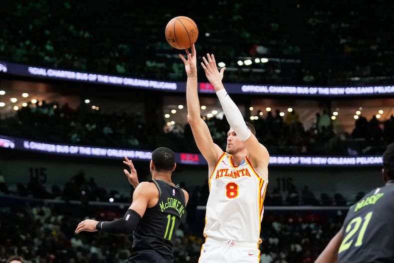 Kristaps Porzingis, pívot de los Hawks de Atlanta, dispara frente a Bryce McGowens, de los Pelicans de Nueva Orleans, el sábado 22 de noviembre de 2025 (AP Foto/Gerald Herbert)