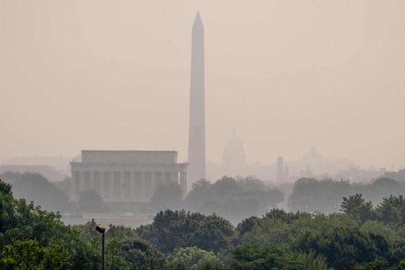 El Monumento a Lincoln, el Monumento a Washington y el Capitolio de Estados Unidos apenas son visibles desde un mirador en Arlington, Virginia, mientras denso humo de incendios forestales cubre el paisaje, el viernes 17 de julio de 2026, en Washington. (AP Foto/J. Scott Applewhite)