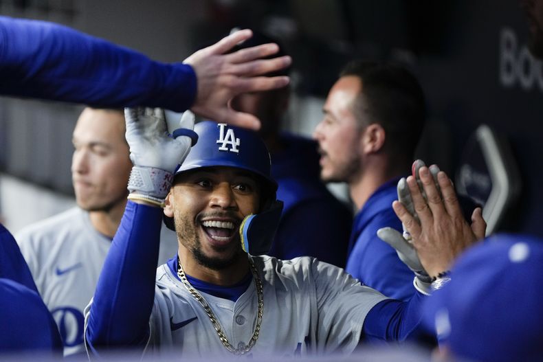 Mookie Betts, de los Dodgers de Los Ángeles, festeja en la cueva luego de conseguir un jonrón en el cuarto juego de la serie divisional de la Liga Nacional ante los Padres de San Diego, el miércoles 9 de octubre de 2024 (AP Foto/Gregory Bull)