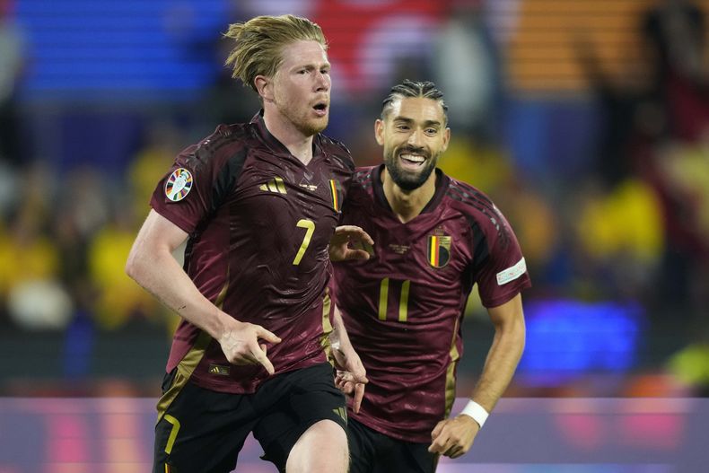 Kevin de Bruyne, de la selección de Bélgica, festeja con su compañero Yannick Carrasco tras anotar ante Rumania en un encuentro de la Euro, disputado el sábado 22 de junio de 2024 en Colonia, Alemania (AP Foto/Martin Meissner)