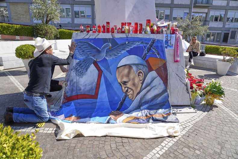 El pintor mexicano Roberto Márquez coloca un retrato del papa Francisco afuera del Hospital Gemelli de Roma, el miércoles 5 de marzo de 2025, donde el pontífice se encuentra hospitalizado. (AP Foto/Gregorio Borgia)