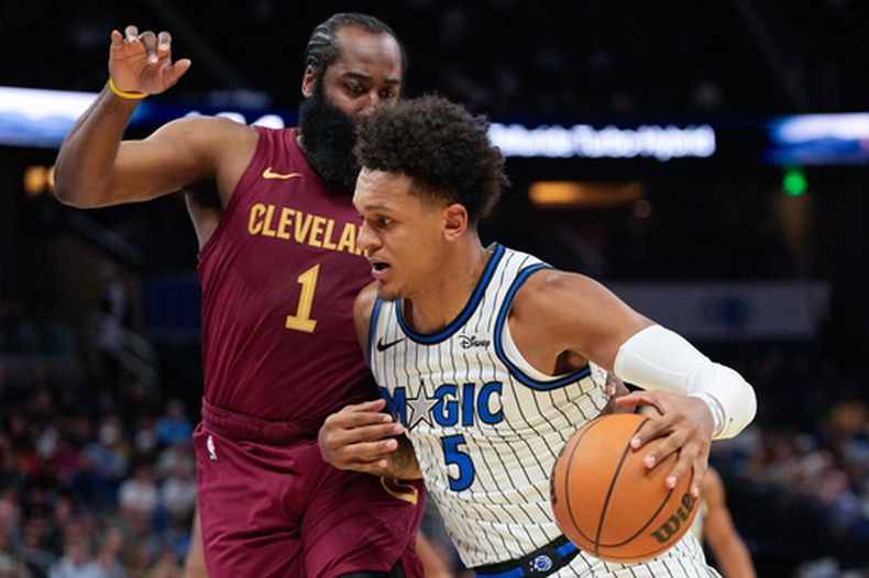 El alero del Magic de Orlando Paolo Banchero supera al alero de los Cavaliers de Cleveland James Harden en el encuentro de pretemporada del martes 13 de octubre del 2026. (AP Foto/John Raoux)