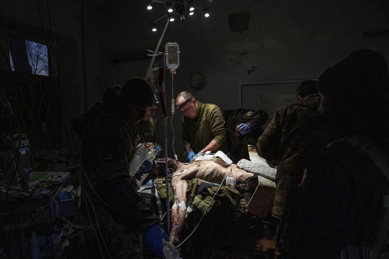 Médicos militares ucranianos atienden a un camarada lesionado que fue desalojado del campo de batalla en el hospital de la región Donetsk, Ucrania, el 9 de enero de 2023. El soldado no sobrevivió. (AP Foto/Evgeniy Maloletka)