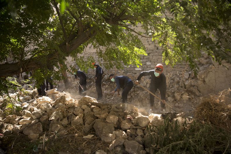 ARCHIVO - Trabajadores de emergencias cavan para buscar cuerpos en una fosa común en Raqqa, Siria, la ciudad que sirvió como capital de facto del grupo Estado Islámico, el 7 de septiembre de 2019. (AP Foto/Maya Alleruzzo, Archivo)