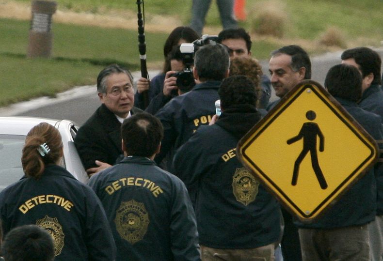 ARCHIVO - Agentes de la policía chilena rodean al expresidente peruano Alberto Fujimori, a la izquierda, a la salida de su casa en Santiago para ser extraditado y enfrentar cargos por violaciones a los derechos humanos y corrupción, el 22 de septiembre de 2007. Su hija, Keiko Fujimori, informó el miércoles 11 de septiembre de 2024 que el exmandatario falleció de cáncer a los 86 años. (AP Foto/Claudio Santana, Archivo)