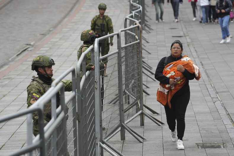 Soldados se ven parados tras cercas colocadas en torno al Palacio de Gobierno en Quito, Ecuador, el viernes 11 de abril de 2025. Los ecuatorianos van a las urnas el 13 de abril para la segunda vuelta de las elecciones presidenciales. (AP Foto/Dolores Ochoa)