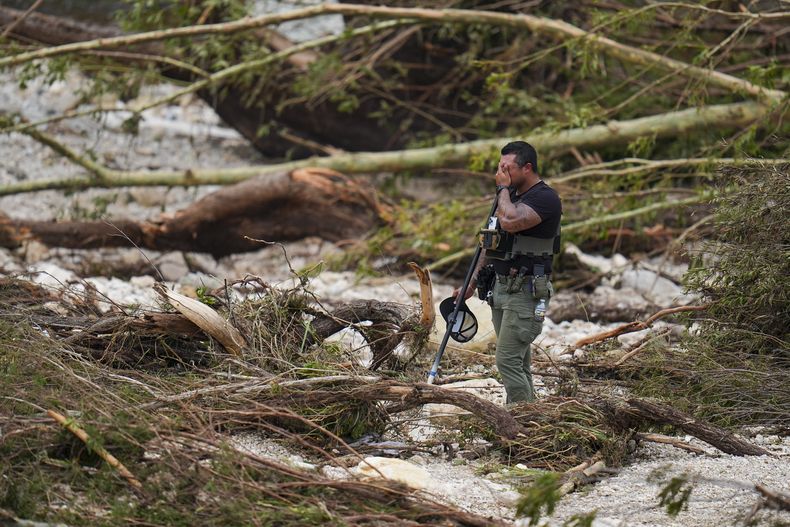 Un policía hace una pausa mientras revisa la orilla del río Guadalupe, cerca del Campamento Mystic, después de que una inundación repentina arrasara el área, el sábado 5 de julio de 2025, en Hunt, Texas. (AP Foto/Julio Cortez)