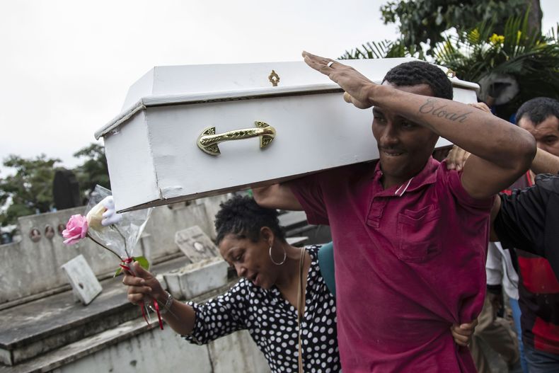 Gilgres Santos, padre de Eloah Passos, de 5 años, carga el ataúd de su hijita para sepultarla en el Cementerio Cacuia, el 14 de agosto de 2023 en Río de Janeiro, Brasil. La niña murió a causa de una bala perdida. (AP Foto/Bruna Prado)