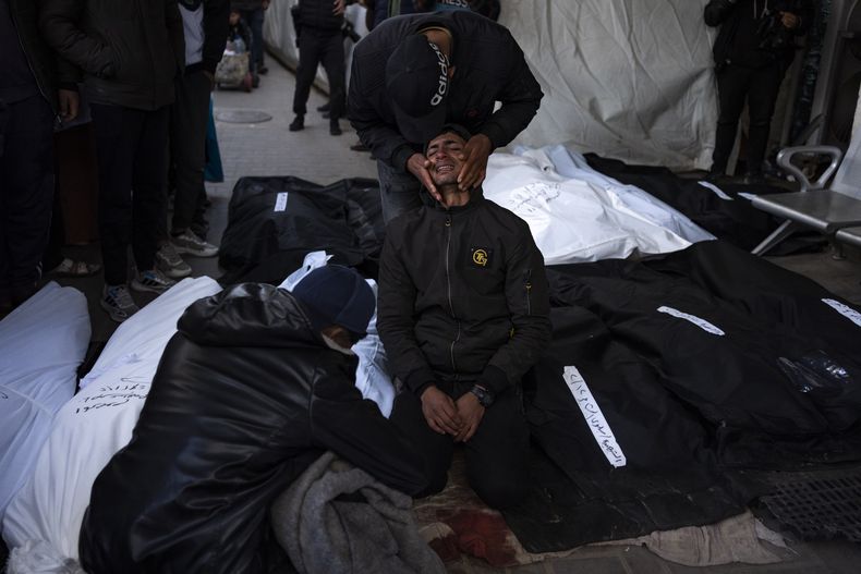 Palestinos lloran a parientes fallecidos en el bombardeo de la Franja de Gaza en una morgue de hospital en Rafah, el lunes 12 de febrero de 2024. El ejército israelí dijo el lunes por la mañana que había rescatado a dos rehenes en la Franja de Gaza. La operación, acompañada de ataques aéreos, mató a decenas de palestinos, según funcionarios locales de salud. (AP Foto/Fatima Shbair)