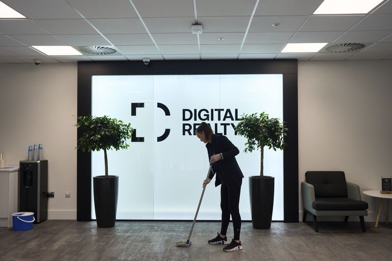 Una empleada de limpieza trapea el área de recepción de un edificio vacío de un centro de procesamiento de datos, el jueves 17 de octubre de 2024, en Dublín, Irlanda. (AP Foto/Bram Janssen)